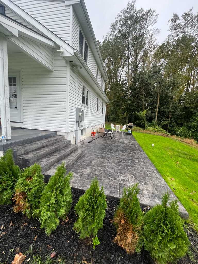 Grey ashlar stamped concrete walkway and steps running alongside a house in Chester County PA